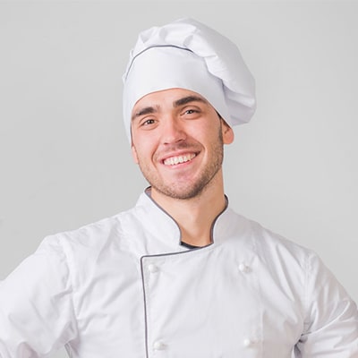 Chef with white hat and uniform smiling